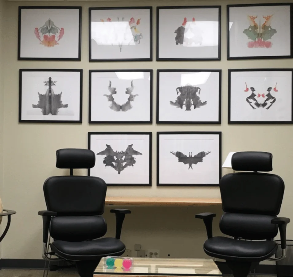 drier and associates office with two chairs and paintings on the wall behind them